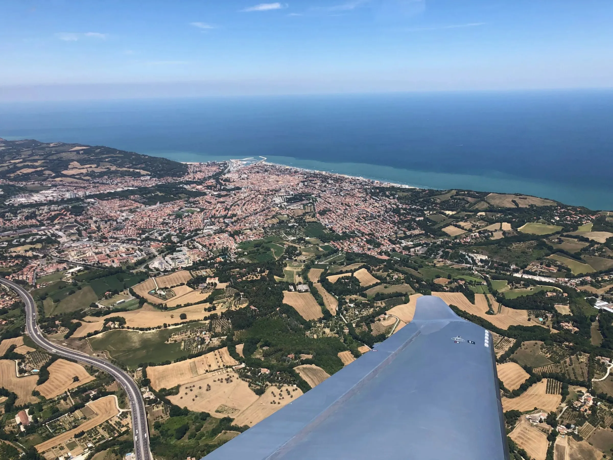 Tragfläche über der Küste im Reiseflug